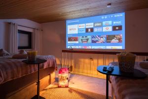 Zimmer mit 2 Tischen und einem großen Bildschirm in der Unterkunft Aussicht auf Natur, Pool, Grill, Kino, Sauna in Schönwald