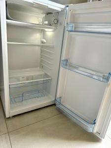 an empty refrigerator with its door open in a kitchen at Chambre pour 2 au calme climatisée in Hundsbach