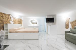 a white bedroom with a bed and a couch at Family JC in Cagliari