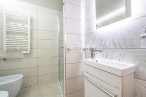 a white bathroom with a sink and a toilet at Family JC in Cagliari +7 photos