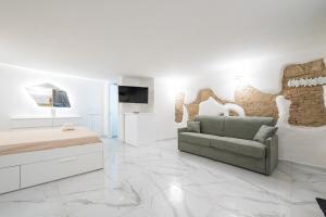 a white bedroom with a bed and a couch at Family JC in Cagliari
