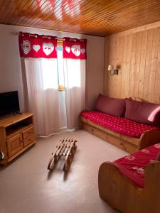 a living room with a couch and a tv in it at Location de la cascade 8 personnes in Besse-et-Saint-Anastaise