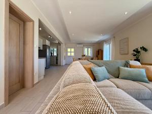 a living room with a large couch and a kitchen at House Bianca Brac - New Listing - Experienced host in Postira