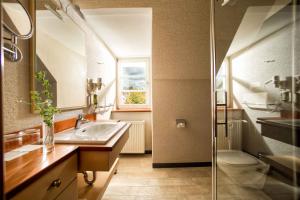 łazienka z umywalką, toaletą i lustrem w obiekcie Garten-Hotel Ochensberger w mieście Sankt Ruprecht an der Raab