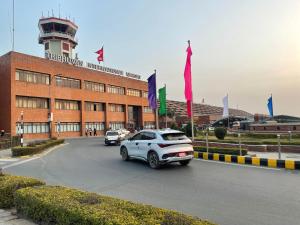 a car parked in front of a building with a control tower at Hotel Bayberry Kathmandu - Near Tribhuvan International Airport in Kathmandu