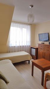 a living room with two beds and a tv at Villa Krystyna in Dźwirzyno