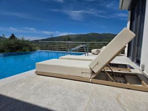 a lounge chair sitting next to a swimming pool at Villa Símera in Laganas