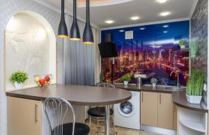 a kitchen with a large painting of a city at Luxury Apartment near ТЦ Україна in Kyiv