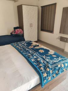 - un lit avec une couverture bleue et blanche dans l'établissement Om Palace, à Mathura