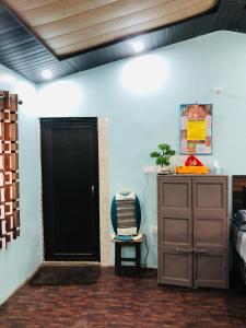 マックトシュワーにあるHimdarshanhomestayの黒いドアと椅子が備わる部屋