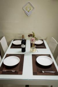 una mesa con platos blancos y una botella de vino en Serenity Home 2, en Hanói