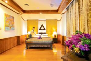un uomo in piedi in una stanza d'albergo con un letto di Oriental Siam Resort - SHA Extra Plus Certified a Chiang Mai Altre 93 foto