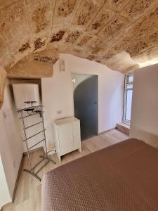 a bedroom with a bed and a wooden ceiling at Vico Farinella 12 Small Room in Polignano a Mare