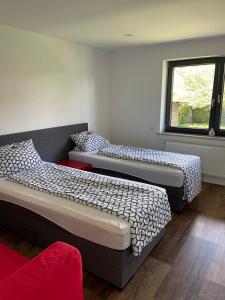 two beds sitting in a room with a window at Bungalow in ruhiger Siedlung mit Terrasse und Stellplatz in Landshut