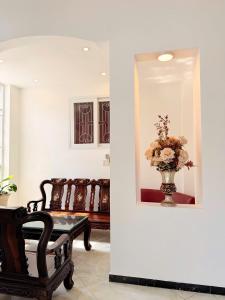 een kamer met een spiegel en een vaas met bloemen bij khách sạn Hồng Tâm in Ho Chi Minh-stad