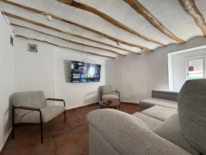 a living room with a couch and chairs and a tv at Casa Kiona in Moratalla