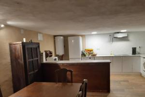 a kitchen with a table and a kitchen with white cabinets at El Mirador de Abionzo in Abionzo