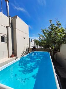 a blue swimming pool in front of a building at Niki's House in Gournes