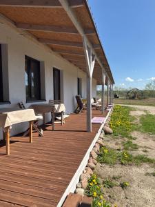 a wooden porch with benches and tables on a house at Siedlisko Agata in Drohiczyn
