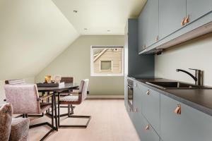 a kitchen with a table and chairs and a sink at Odda Living - 3BR & 1BR - A3 in Tokheim
