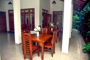 una sala da pranzo con tavolo e sedie in legno di Janapriya Lake Resort a Polonnaruwa
