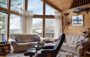 un soggiorno con divani, tavoli e finestre di 3 Bedroom Gorgeous Home In Jørpeland a Jørpeland