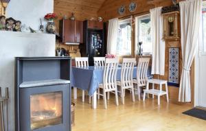 un soggiorno con camino, tavolo e sedie di 3 Bedroom Gorgeous Home In Jørpeland a Jørpeland