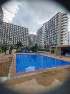 a large apartment building with a large swimming pool at Adam&Eva Condo Staycation in Lapu Lapu City