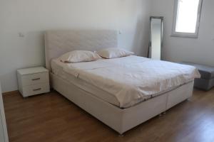 a bedroom with a large bed with a white headboard at Villa Nirvana in Mostar
