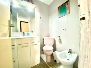 een witte badkamer met een toilet en een wastafel bij Apartamento vista mar Tarifa in Tarifa
