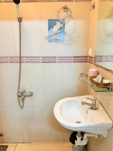 een badkamer met wastafel en douche bij khách sạn Hồng Tâm in Ho Chi Minh-stad