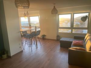 een woonkamer met een bank, een tafel en stoelen bij Apartamento vista mar Tarifa in Tarifa