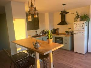 een keuken met een houten tafel en een witte koelkast bij Apartamento vista mar Tarifa in Tarifa +6 foto's