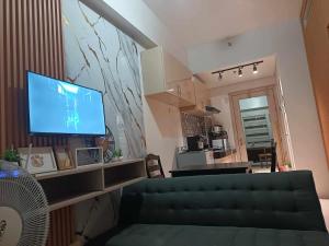 a living room with a couch and a flat screen tv at Cheers SMDC Condominium in Marilao