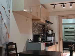 a kitchen with a table and a counter top at Cheers SMDC Condominium in Marilao +18 photos
