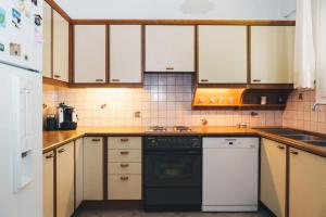 a kitchen with white cabinets and a black dishwasher at Villa Melivia in Hersonissos