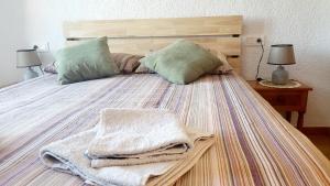 a large bed with pillows and towels on it at La Casita Denia in Els Poblets