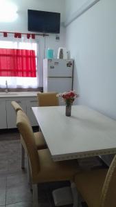 a kitchen with a table and chairs with a vase of flowers at hospedaje monte grande in Monte Grande