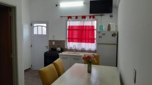 a kitchen with a table with a vase of flowers on it at hospedaje monte grande in Monte Grande