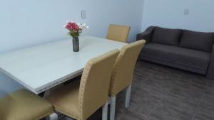 a table with chairs and a vase with flowers on it at hospedaje monte grande in Monte Grande