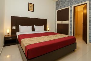 RudrapurにあるHotel Crown Plazaの赤い毛布が掛けられた大きなベッドのある寝室