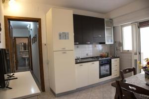 a kitchen with white cabinets and a sink and a table at casa vacanze Gina in Marina di Pescoluse