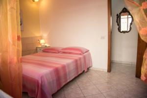 a bedroom with a bed with a pink blanket at casa vacanze Gina in Marina di Pescoluse