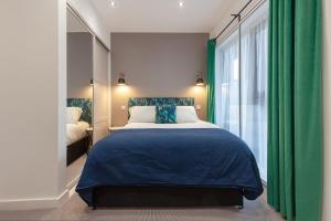 una camera con letto e tenda verde di KSpace @ The Point a Sheffield