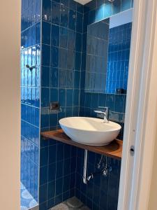 a bathroom with a sink and blue tiled walls at Collimare Rooms & Sailing near 5 Terre in Vezzano Ligure