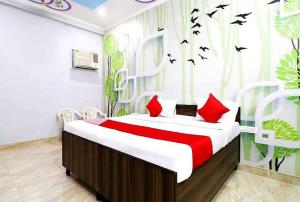 a bedroom with a bed with birds on the wall at Hotel O Smart City Guest House in Ballabgarh