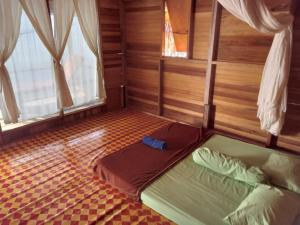 a bedroom with a bed in a room with wooden walls at Sehati Homestay - Raja Ampat in Besir +53 photos