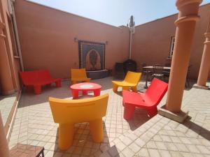 Chambre 4, Riad 3 Couple only au village naturiste في كاب داغد: مجموعة من الكراسي الملونة والطاولات على الفناء +5 صور