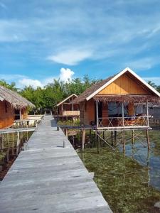a row of houses on the water with a dock at Sehati Homestay - Raja Ampat in Besir