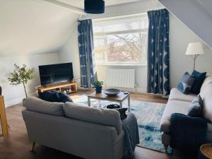 a living room with a couch and a table at Ideal Contractor Business & Family Friendly 2-Bed Apartment Quiet & Spotless with Fast WiFi Large Screen Smart TV in Wakefield